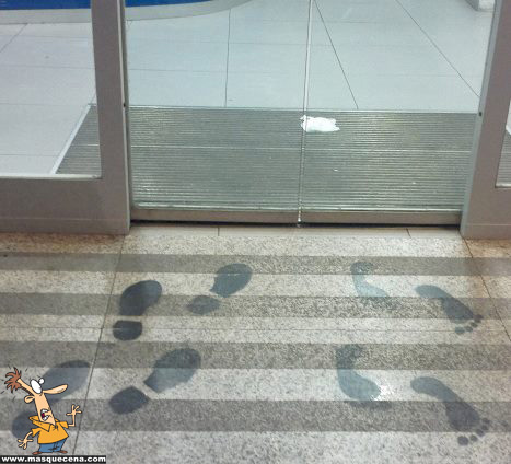 Imagem que mostra a porta de entrada de um Banco Português. As pessoas entram com sapatos e saem descalças
